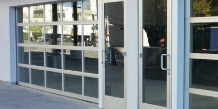 Retail store aluminum glass panel door installation services, Garage Door Customs.